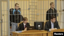 Dzmitry Kanavalau (left) and Ulad Kavalyou are seen in the defendants' cage before court hearings in Minsk on September 15, 2011.