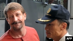 Alleged Russian arms dealer Viktor Bout is escorted by police as he arrives for a hearing at the Criminal Court in Bangkok on August 20.