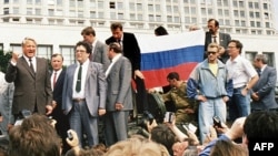 Boris Yeltsin (far left) standing atop an armored vehicle during the heady days of August 1991.