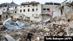 A man walks among the debris of destroyed buildings hit by shelling in a residential area of the city of Ganca during the ongoing military conflict between Armenia and Azerbaijan over the breakaway region of Nagorno-Karabakh on October 22.