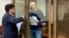 Vladimir Kara-Murza (right) talks to his lawyer, Vadim Prokhorov, during a preliminary court hearing in Moscow on March 6.