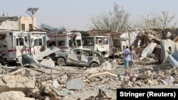 Damaged vehicles are seen at the site of a car bombing in Qalat, capital of Zabul Province, on September 19.