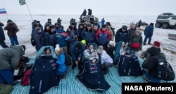 Joe Acaba (left) and Mark Vande Hei of the United States (right), and Aleksandr Misurkin of Russia relax under blankets after landing in a remote area of Kazakhstan on February 28.