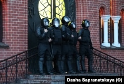 OMON guard the entrance to the church as around 50 arrests were made on the square outside.