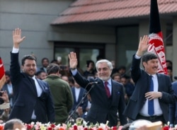 Abdullah Abdullah (center) gestures to his supporters after his own swearing-in ceremony in Kabul on March 9.