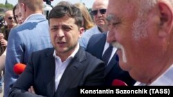 Ukrainian President Volodymyr Zelenskiy (left) talks to local residents in the central city of Cherkasy on July 31.