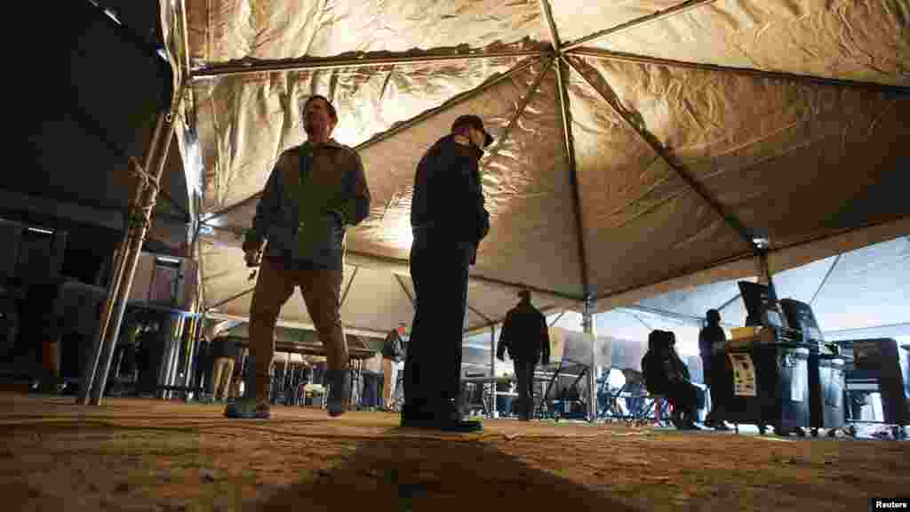 A voter walks past a New York police officer inside a tent at a polling site built to service residents of the Queens borough neighborhoods of Breezy Point and the Rockaways, whose original site was devastated by superstorm Sandy.