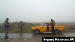 Ukrainian police officers stop a car to check documents at a checkpoint in Berdyansk in eastern Ukraine on November 28. 