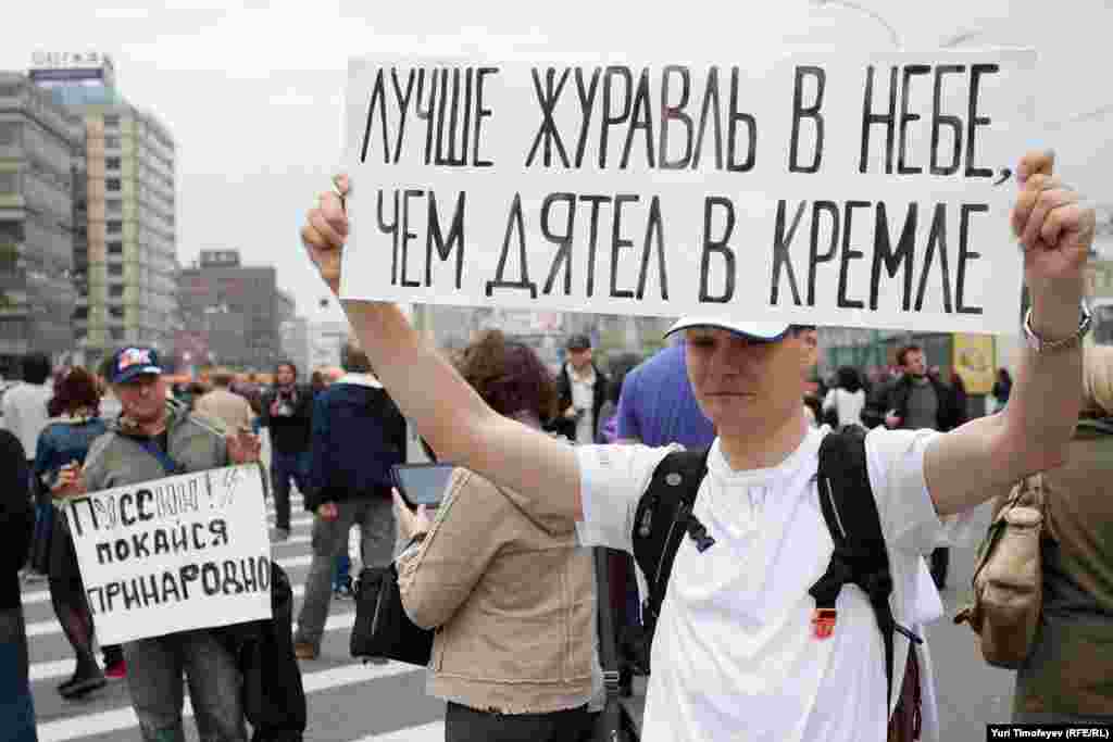 In another vulgar Russian reference, this man holds up a sign that says: &quot;A crane in the sky is better than a woodpecker in the Kremlin.&quot; 