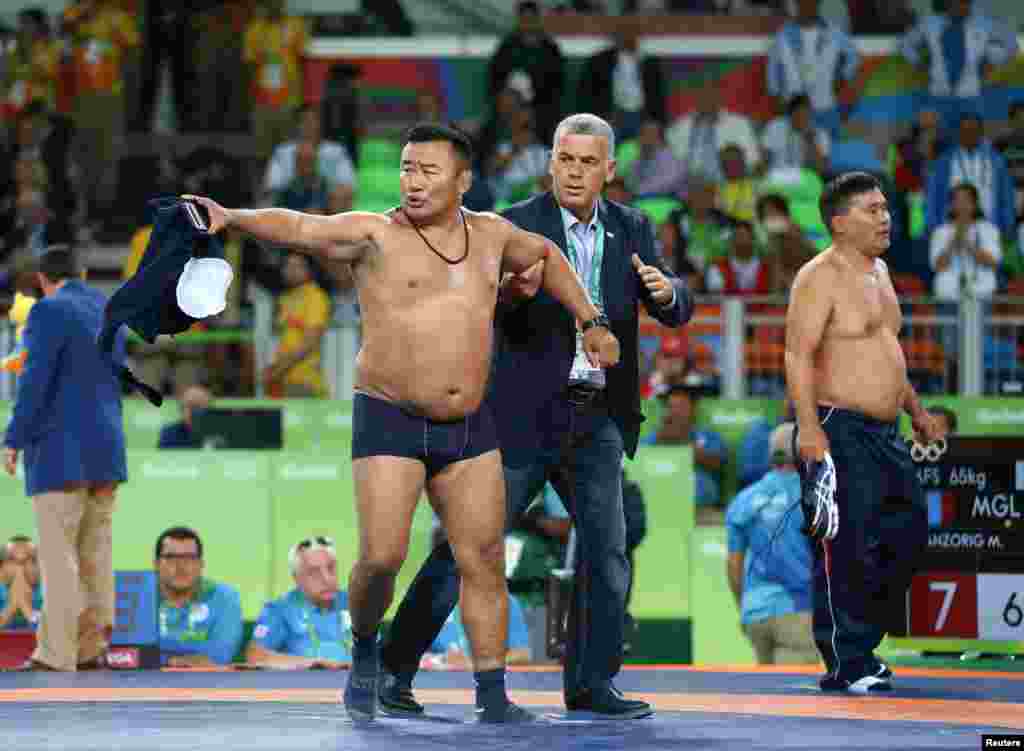 Things got ugly and rather comical when two Mongolian wrestling coaches stripped off their clothes to protest a referee&#39;s decision to penalize Mandakhnaran Ganzorig as he celebrated a sure victory late in his match against Uzbek wrestler Ikhtiyor Navruzov. The Uzbek ended up winning when the Mongolian team lost its appeal, giving Navruzov an additional point. 