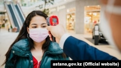 A woman has her temperature checked as a preventive measure against the coronavirus at a shopping mall in Nur-Sultan on May 4.