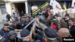 Ukrainian security personnel block supporters of Yulia Tymoshenko during a protest rally outside the court in Kyiv on August 8.