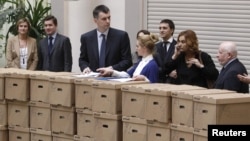 Mikhail Prokhorov (third from left) and members of his campaign staff and election officials appear with boxes containing signatures to support his presidential candidacy at the Central Election Commission in Moscow on January 18.