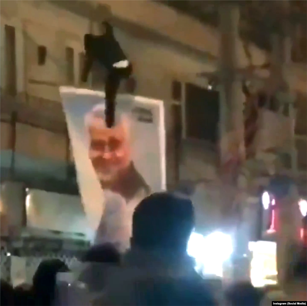 A protester kicks a poster of slain Iranian military commander Qasem Soleimani in Tehran on January 12.