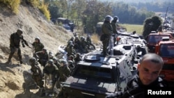 A Kosovo Serb man sits on a truck in front of Kosovo Force (KFOR) soldiers from Germany in the village of Jagnjenica near the town of Zubin Potok, near the disputed border with Serbia, in late October.