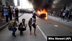 An Atlanta Police Department vehicle burns as people pose for a photo during a demonstration against police violence on May 29.