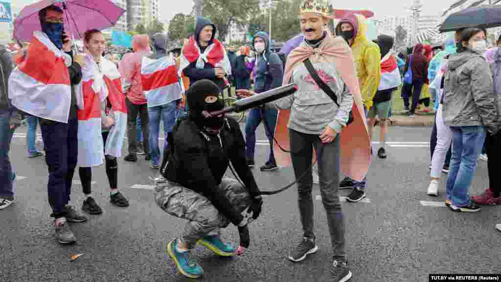 Protesters dressed as Lukashenka and a security officer attend a rally in Minsk.