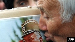 A supporter of the ultranationalist Serbian Radical Party kisses a picture of Ratko Mladic.