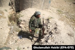 An Afghan security official stands guard at a check point in restive Laghman Province on May 25.