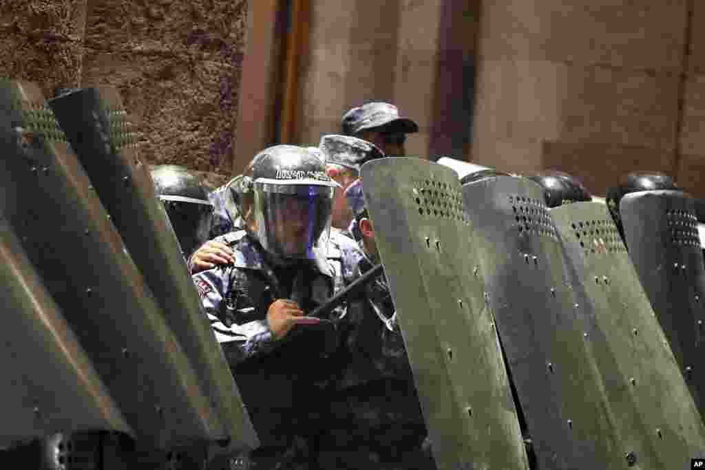 Police officers block an entrance to the government building in Yerevan during a protest against Prime Minister Nikol Pashinian in Yerevan on September 20. Protesters gathered in central Yerevan, blocking streets and demanding that authorities defend Armenians in Nagorno-Karabakh.