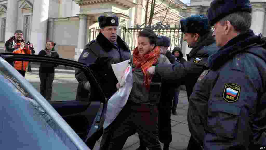 Police officers detain a gay-rights activist who tried to protest against antigay legislation in St. Petersburg on April 6, 2012.