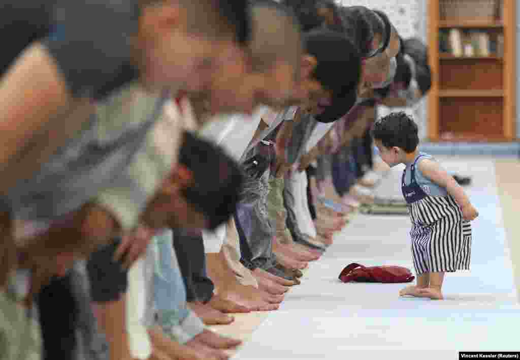 A child walks near people attending midday prayers at Strasbourg Grand Mosque in Strasbourg, France on the first day of Ramadan. (Reuters/Vincent Kessler)