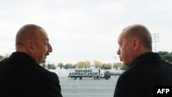 A picture taken last month shows Turkish President Recep Tayyip Erdogan (right) and Azerbaijani President Ilham Aliyev attending a military parade in Baku marking Azerbaijan's declared victory against Armenia over the breakaway Nagorno-Karabakh region.