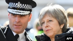 U.K. Prime Minister Theresa May (right) is shown the areas in Salisbury visited by Sergei Skripal and his daughter after they were exposed to a nerve agent. 