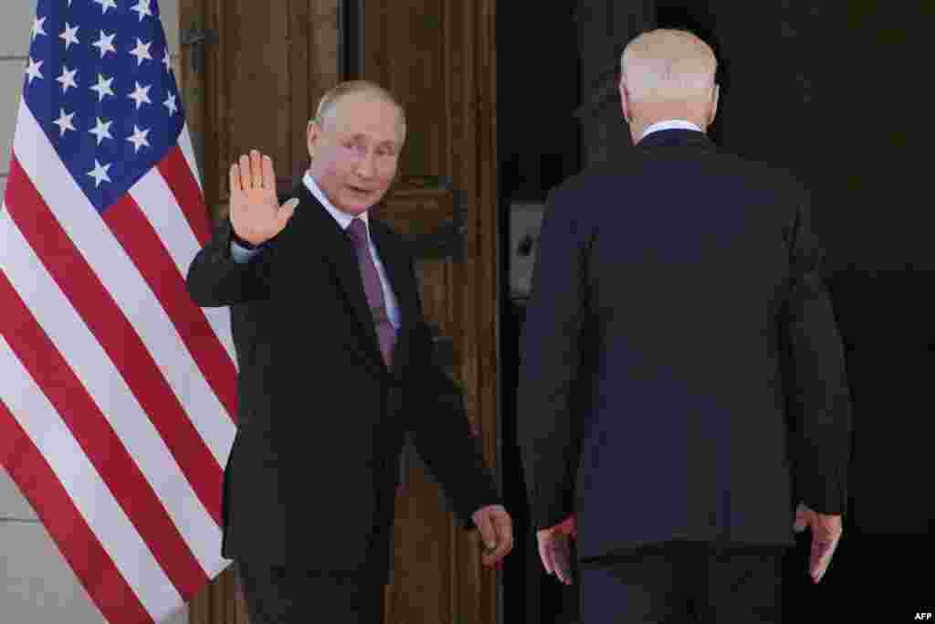 Putin waves before entering the villa with Biden (right).&nbsp;