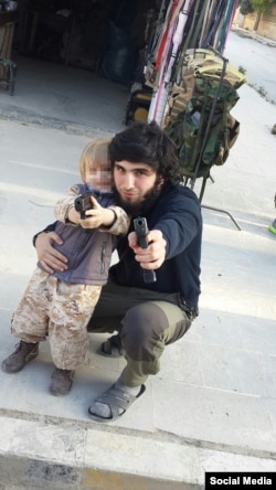 Mansur Shishani and a toddler posing with guns