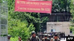 Soldiers leave after casting ballots during early voting at a polling station in Osh on June 25.