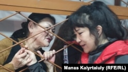 Zhazira Demeuova (right) and Gulzipa Zhaukerova talk in the courtroom during the trial in Almaty on November 6.