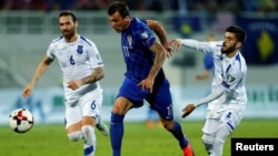 Two Kosovar players (in white) attempt to close down a Croatian forward during Kosovo's qualifying match for the 2018 World Cup last year. 