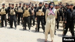 Kurdish pop star Helly Luv poses in front of Kurdish Peshmerga troops at a base in Dohuk.