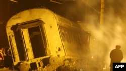 Workers inspect a damaged railway carriage from the earlier bombing on November 27-28, which killed 26 people.