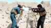 FILE: Members of the Afghan security forces take position during an operation against Taliban in Helmand province in April 2017.