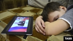 A boy in Vladivostok sleeps as his tablet computer shows Vladimir Putin's annual state-of-the-nation address on December 12.