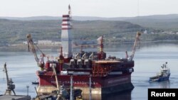 A floating oil platform is tugged from the harbor in the northern Russian port of Murmansk.