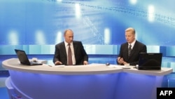 Russian Prime Minister Vladimir Putin (left) answers questions during a nationally televised town-hall-style session in Moscow.