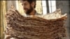 An Iranian man carries a stack of the traditional bread known as sangak.