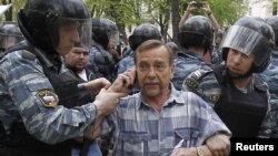 Riot police detain human rights activist Lev Ponomaryov during an unsanctioned protest in Moscow on May 7.