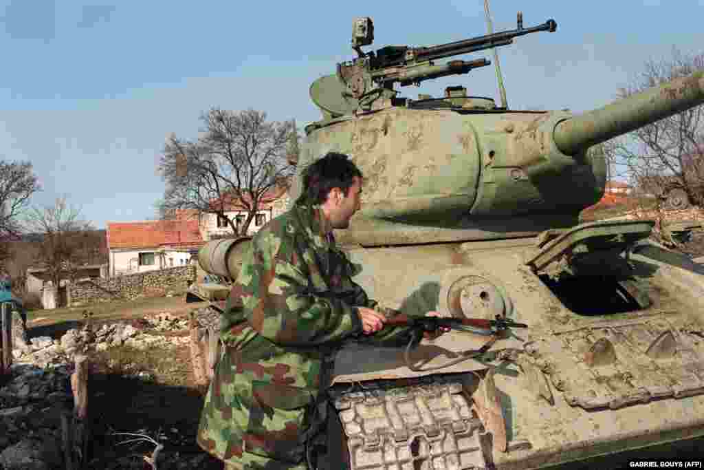 An ethnic&nbsp;Serbian fighter next to a Soviet-made T-34/76A medium tank built during World War II, in Knin, Croatia,&nbsp;on February 3, 1993.