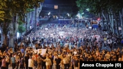 Protests march toward the Georgia Dream headquarters in central Tbilisi early on June 23.