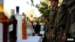 Iranian police display alcohol after breaking up illicit parties and making arrests in Tehran in October 2010