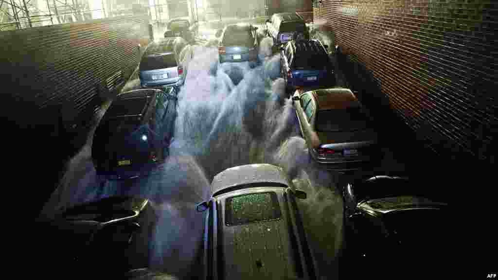 Rising water rushes into a subterranean parking garage in the financial district of New York.