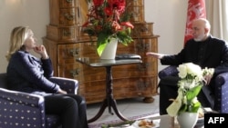 U.S. Secretary of State Hillary Clinton (left) and Afghan President Hamid Karzai speak during a bilateral meeting in Bonn.