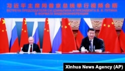 Chinese President Xi Jinping (right) talks with Russian President Vladimir Putin via video conference on June 28.