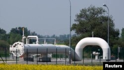 Gas pipes are pictured behind a field of rapeseed at Austria's largest natural-gas import and distribution station in Baumgarten.