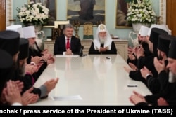 Ukrainian President Petro Poroshenko (center left) and Patriarch Filaret (center right) meet with members of the clergy of the Ukrainian Orthodox Church in Kyiv on October 21.