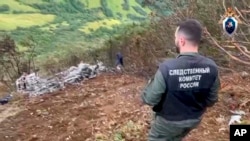 A Russian official surveys the scene of the helicopter crash in the Kamchatka region.